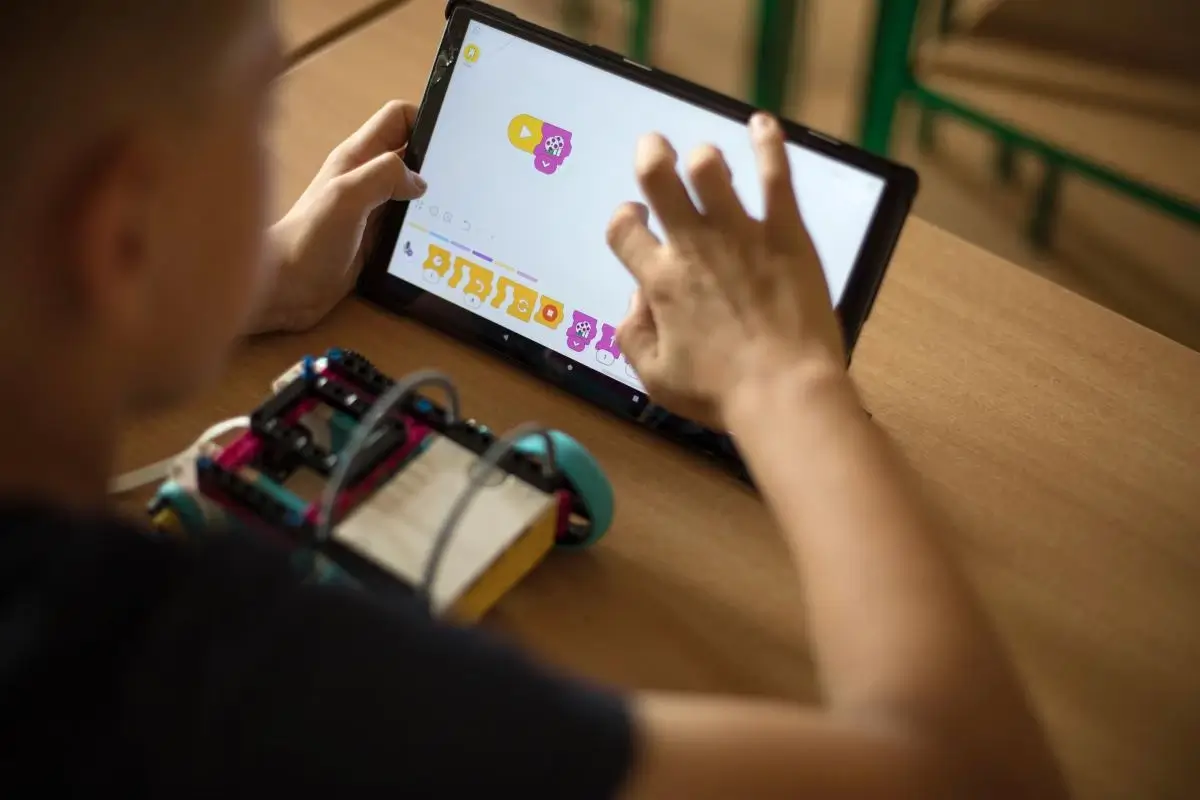Chłopiec programujący robota na tablecie
